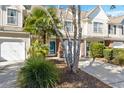 Inviting townhouse showing a landscaped front yard with a blue front door at 8653 Grassy Oak Trl, North Charleston, SC 29420