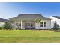 The backyard features a screened porch, a well-maintained lawn, and lush landscaping at 1003 Sagegrass St, Summerville, SC 29485