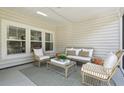 The screened porch features neutral decor, a comfortable seating area, and ample natural light at 1003 Sagegrass St, Summerville, SC 29485