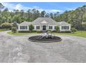 Charming single-story home with circular driveway, classic white facade, and lush, manicured landscaping at 1019 Spiers Cir, Bonneau, SC 29431