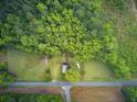 Aerial view of a home nestled among trees with a well-maintained lawn and surrounding open fields at 1050 Mt Zion Rd, Saint George, SC 29477