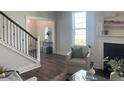 Cozy living room with a fireplace, large windows, staircase, and view into entryway at 109 Crosscut Ln, Summerville, SC 29486