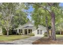 View of a cute home with a lawn and front door; a tree stands to the left at 115 Ridge Rd, Summerville, SC 29485