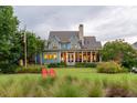 Stunning back exterior with a sprawling lawn, mature trees and beautiful screened in porch at 187 Ithecaw Creek St, Daniel Island, SC 29492