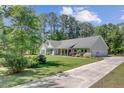 Beautiful one-story home with lush green lawn and long driveway on a sunny day at 209 Cheyenne Rd, Summerville, SC 29483
