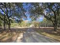 A view of the home down a shady tree-lined driveway at 2300 Bethera Rd # A, Bonneau, SC 29431