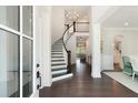 Elegant foyer with a curved staircase, hardwood floors, and a chandelier, creating a grand entrance at 2372 Darts Cove Way, Mount Pleasant, SC 29466