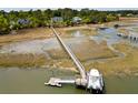 Aerial view of a private pier and dock with a boat, surrounded by marsh and waterfront homes at 2372 Darts Cove Way, Mount Pleasant, SC 29466