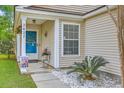 Inviting front porch featuring a blue door, decorative plants, and white stone landscaping at 2427 Stingray Blvd, North Charleston, SC 29406
