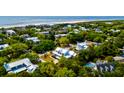 Scenic aerial shot of a coastal community with numerous homes surrounded by dense trees and a pristine beach at 2870 Ion Ave, Sullivans Island, SC 29482