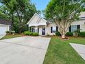 Charming home showcasing a well-maintained front yard, driveway and detached garage at 325 Dupont Way, Summerville, SC 29485