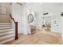 Inviting foyer with wood flooring, decorative rug, staircase, and views into adjacent living spaces at 337 Evian Way, Mount Pleasant, SC 29464