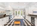 Bright kitchen featuring marble countertops, stainless steel appliances, and an island with seating and black-and-white flooring at 34 Eugenia Ave, Kiawah Island, SC 29455