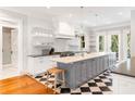 Bright kitchen featuring marble countertops, stainless steel appliances, and an island with seating and black-and-white flooring at 34 Eugenia Ave, Kiawah Island, SC 29455