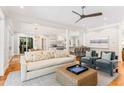 Sunlit living room featuring hardwood floors, ceiling fan, designer furniture, and sliding doors to the outdoor space at 34 Eugenia Ave, Kiawah Island, SC 29455