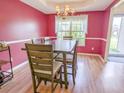 Dining room area with pink walls, trim detail, chandelier, and natural light at 5276 Copley Cir, Summerville, SC 29485