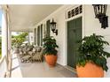 Inviting porch featuring comfortable seating, potted plants, and a green front door at 6 Judith St, Charleston, SC 29403