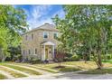 Two-story home with yellow brick exterior and a covered front porch surrounded by beautiful, mature trees at 7 Chadwick Dr # A, Charleston, SC 29407