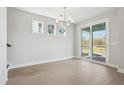 Bright dining room featuring hardwood flooring, a decorative chandelier, and access to the porch at 104 Hawthorne Landing Dr, Goose Creek, SC 29445