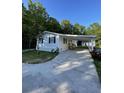 Charming single-story home with a covered front porch and long driveway nestled among lush trees at 1070 French Quarter Creek Rd, Huger, SC 29450