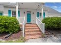 Inviting front porch with brick steps, white railings, and a vibrant blue front door at 114 Shadowmoss Pkwy, Charleston, SC 29414