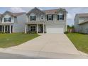 Charming two-story home featuring gray siding, black shutters, a two-car garage, and a well-manicured lawn at 114 W Bradford Pointe Dr, Summerville, SC 29483