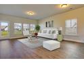 Bright living room with hardwood floors, large windows, contemporary furnishings and lots of natural light at 157 Threaded Fern St, Summerville, SC 29485