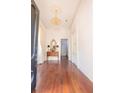 Bright foyer featuring hardwood floors, a decorative mirror, and a beautiful chandelier at 192 Ashley Ave # C, Charleston, SC 29403