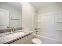 Bright bathroom showcasing a granite countertop vanity and shower with white tiled walls at 2606 Bennett Yard Rd, North Charleston, SC 29405