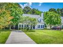 Beautiful home exterior with lush green lawn, mature trees and paved driveway at 3084 Queensgate Way, Mount Pleasant, SC 29466
