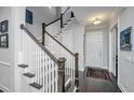 Elegant foyer with dark wood floors, a staircase with white railings, and a view of the front door at 3769 Maidstone Dr, Mount Pleasant, SC 29466
