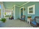 Inviting front porch with wicker chairs, colorful cushions, and a charming wreath on the teal front door at 3769 Maidstone Dr, Mount Pleasant, SC 29466