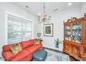 Cozy living room with red sofa, decorative pillows, a china cabinet and chandelier at 3769 Maidstone Dr, Mount Pleasant, SC 29466