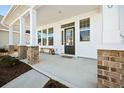 Inviting covered front porch with brick pillars, a bench, and a decorative glass front door at 490 Rowley Ln, Summerville, SC 29486