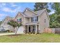 Inviting two-story home with a manicured lawn, showcasing stone accents and an attached two-car garage at 5228 Fallow Fawns Rd, Hollywood, SC 29449