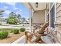 Cozy front porch featuring comfortable seating, beautiful landscaping, and inviting curb appeal at 5228 Fallow Fawns Rd, Hollywood, SC 29449