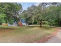 View of home, shows yard with mature tree and mulched flower beds and elevated entrance at 5669 Sands Rd, Hollywood, SC 29449