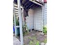 Backyard featuring damaged wood siding and overgrowth at 6 Moultrie St, Charleston, SC 29403
