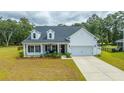 Inviting two-story home with charming front porch, manicured lawn, and attached garage at 7070 Pumpkinseed Dr, Johns Island, SC 29455