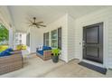 Cozy, covered porch featuring comfortable wicker seating and a stylish ceiling fan at 7070 Pumpkinseed Dr, Johns Island, SC 29455