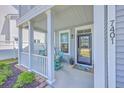 Inviting covered front porch with rocking chairs and decorative plants at a beautiful two-story home at 7401 Purser Ln, Hanahan, SC 29410