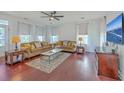 Bright living room featuring hardwood floors, comfortable seating, and large windows with natural light at 7401 Purser Ln, Hanahan, SC 29410