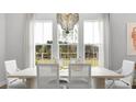 Bright dining room with large windows offering scenic views and a designer chandelier at 778 Clay Field Trl, Summerville, SC 29485