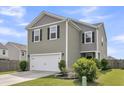 Well-kept two-story home showcasing a two-car garage, stylish siding, and neat landscaping at 9706 Fanning Basket Ln, Ladson, SC 29456