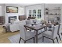 Elegant dining area with a table for six, a fireplace, and large windows that offer ample natural light at 1017 Swamp Rose Run, Summerville, SC 29485