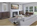 Cozy living room with a fireplace, hardwood floors, and stylish decor at 1017 Swamp Rose Run, Summerville, SC 29485