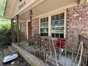 Close-up of the home's porch featuring brick columns, iron railings, and seating area at 1022 Miles Jamison Rd, Summerville, SC 29485