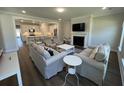 Bright and airy living room with fireplace, modern furniture, and open-concept layout leading to the kitchen at 104 Pine Waters Ln, Summerville, SC 29483