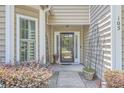 A welcoming porch with decorative plants leading to a glass-paneled front door at 105 Irish Oak Dr, Goose Creek, SC 29445
