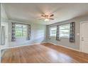 Bright living room featuring hardwood floors, ceiling fan, and three windows offering natural light at 108 Helen Dr, Summerville, SC 29483